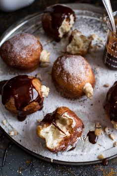 several pastries with chocolate sauce and nuts on a plate