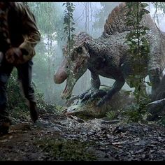 two dinosaurs walking through the woods in front of people