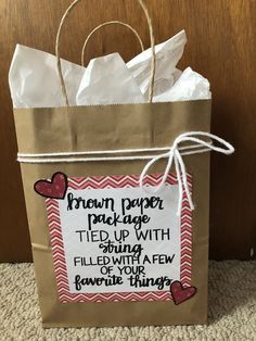 a brown paper bag with writing on it and some hearts attached to the handle that says, brown paper package tied up with string