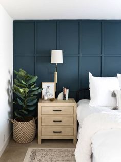 a bedroom with blue walls and white bedding