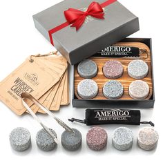 an assortment of silver and white glittered rocks in a box with scissors, tags, and labels