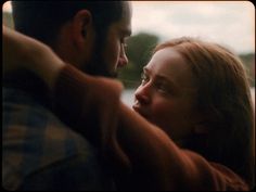 a man and woman embracing each other in front of a window with the sun shining on them