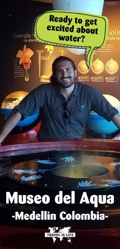 a man sitting at a table in front of a sign that says museum del aqua