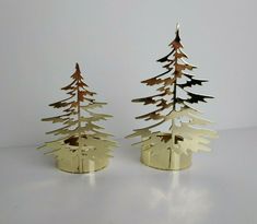 two metal christmas trees sitting next to each other