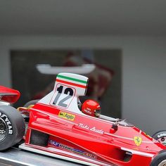 a red race car is on display in a museum