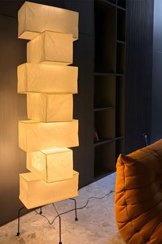 a lamp sitting on top of a table next to a chair and bookshelf