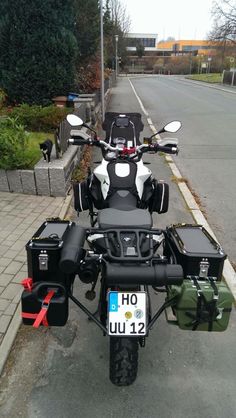 the motorcycle is parked on the side of the road with its luggage strapped to it