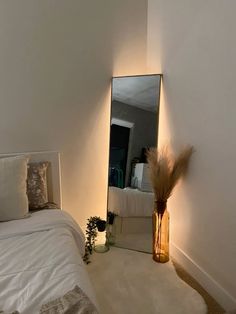 a white bed sitting next to a tall mirror