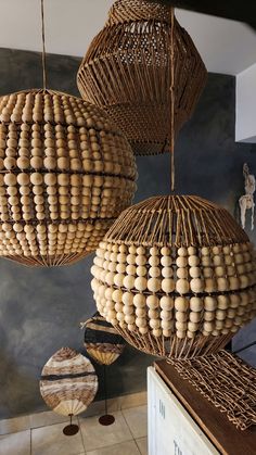 three hanging baskets made out of wood and wicker on display in a room with tile flooring