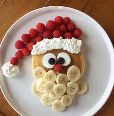 a white plate topped with fruit and a face made to look like a person's head