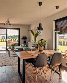 a dining room table with chairs and plants