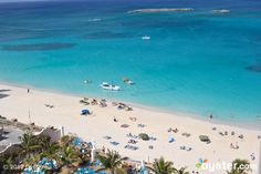 an aerial view of a beach with blue umbrellas and people on the sand near water