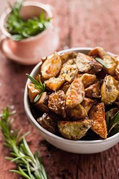 a white bowl filled with fried potatoes and herbs