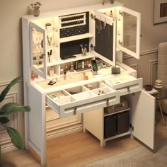 a white vanity with drawers and lights on it in a room next to a potted plant