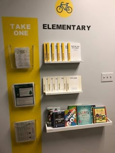 there are several books on the shelves next to each other in front of a sign that says take one elementary