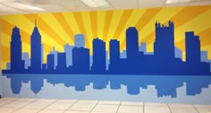 a large city skyline painted on the side of a wall in an empty room with tile flooring