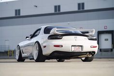 a white sports car parked in front of a building