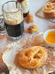 a table topped with pastries next to a cup of tea and a bottle of beer