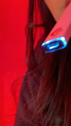 a close up of a person holding a toothbrush in their hand with red light coming from it