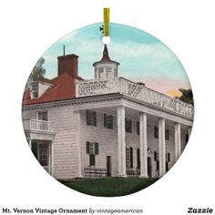 a round ornament with an image of a large white house on it's side