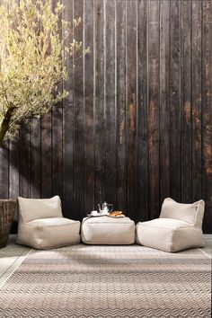 a living room with two white couches and a tree in the corner on top of it