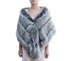 a woman is wearing a gray fur stole