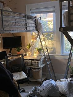 a bedroom with bunk beds and lots of clutter on the floor in front of a window