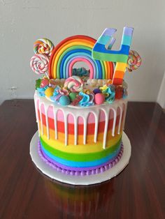 a birthday cake decorated with candy, lollipops and candies on a wooden table