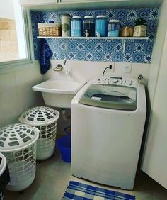 a washer and dryer sitting next to each other in a room with blue tiles on the walls