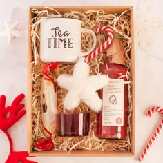 a christmas gift box with two mugs, peppermint, and other items