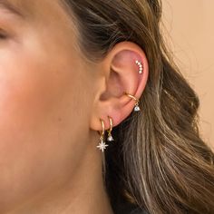 a close up of a person with ear piercings on their ears and wearing earrings