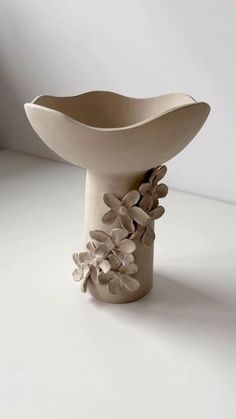 a white vase sitting on top of a table