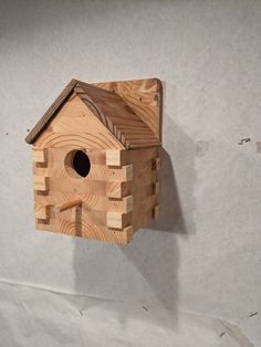 a wooden birdhouse hanging on the wall