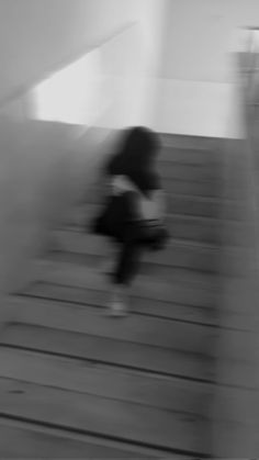 a blurry image of a person sitting on a wooden floor next to a wall