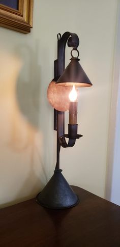 a table with a lamp on top of it next to a wall mounted light fixture