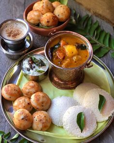 some food is sitting on a plate with two cups and sauces next to it