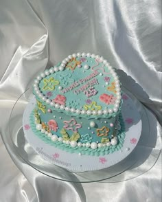 a decorated birthday cake sitting on top of a glass plate