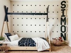 a bedroom with black and white decor on the walls, including a wooden bed frame