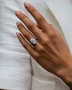 a woman's hand with a diamond ring on it