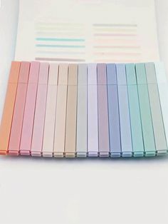 several different colored pens sitting next to each other on top of a white sheet of paper