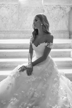 a woman in a wedding dress sitting on the steps