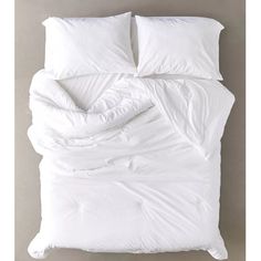 an unmade bed with white sheets and pillows