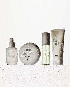 three different types of skin care products sitting on a counter top with drops of water