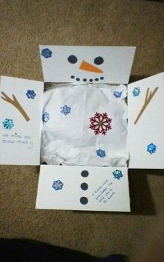 an open box with snowmen on it and some writing on the inside is sitting on the floor