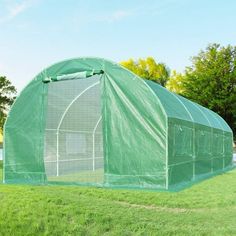 a large green house sitting on top of a lush green field