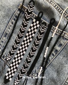 some scissors are in the back pocket of someone's jean jacket, which is decorated with black and white chevron stitchs