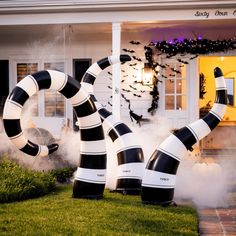 inflatable black and white sculptures are on the lawn outside a house with bats