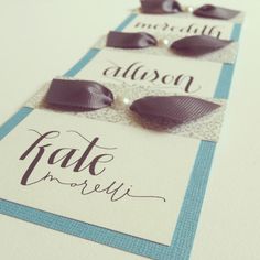 three place cards with bows and pearls on them