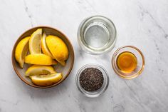 bowls filled with lemons and spices on top of a white countertop next to two glasses