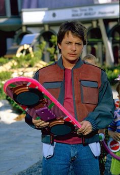 a man holding a pink skateboard in his hands